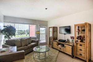a living room with a couch and a tv at Resort-Style Condo with Pool 19 Miles to Fort Myers in Burnt Store Marina