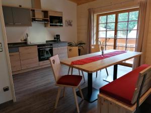 une cuisine avec une table en bois, une table et des chaises dans l'établissement Ferienwohnung mit Loggia, à Oberstdorf