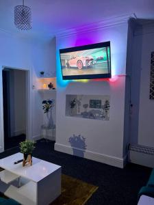 ein Wohnzimmer mit einem Flachbild-TV an der Wand in der Unterkunft Home in Levenshulme, Manchester in Manchester
