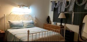 um quarto com uma cama, um candeeiro e uma cómoda em CASA BETTY COSTAMBAR em San Felipe de Puerto Plata