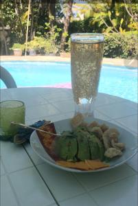 un plato de comida en una mesa con un vaso en CASA BETTY COSTAMBAR en San Felipe de Puerto Plata