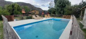 a swimming pool in a yard with a house at Complejo de Cabañas Tierra de Luna in Potrerillos