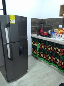 a refrigerator next to a counter with fruits and vegetables at EL EDÉN in Puerto Triunfo