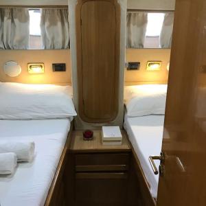 two twin beds in a small room with two bedsskirts at Motor yacht 45' in Egina