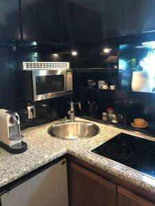 a kitchen with a sink and a microwave at Motor yacht 45' in Aegina Town