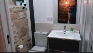 a bathroom with a sink and a toilet and a mirror at La Bodega in Andújar