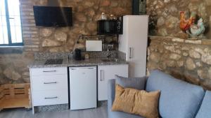 a kitchen with a counter and a refrigerator and a couch at La Bodega in Andújar