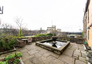 a stone patio with a fountain in the middle at The Rock House - Main House in Edinburgh