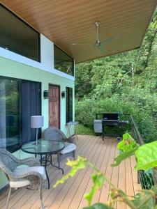 un patio con mesa, sillas y piano en Modern cabin nestled in mountain nature. Paradise!, en Orosí