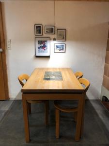 a wooden table in a room with two chairs at Chalet Weidli in Achseten