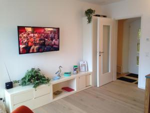 a living room with a tv hanging on the wall at Casa Isabella in Riva San Vitale