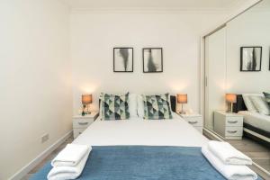una camera da letto con un grande letto bianco con due lampade di Superb flat close to super famous Portobello Road a Londra