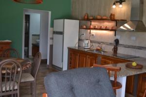 cocina con nevera y mesa con sillas en Aires del Alto - casas en Tafí del Valle