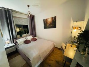 a small bedroom with a bed and a window at NaturaApart bezpłatny parking in Ostrołęka