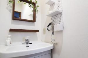 a white bathroom with a sink and a mirror at Otsuka Residence - Vacation STAY 19855v in Tokyo