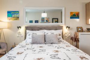 1 dormitorio con 1 cama con edredón blanco en Apartments Stella Mariela, en Šibenik