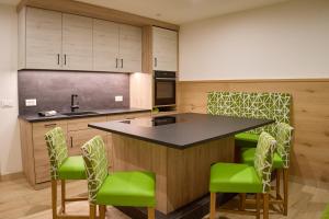 a kitchen with green chairs and a black counter top at GSCNARA - APARTMENT LIN in Antermoia