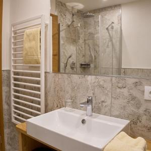 a bathroom with a white sink and a shower at GSCNARA - APARTMENT LIN in Antermoia