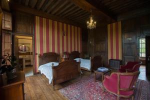 a bedroom with two beds and a table and chairs at Le Logis d'Equilly in Équilly