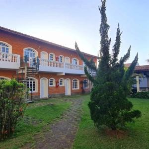 a building with a tree in front of it at Pousada Tannenhoff Caraguatatuba in Caraguatatuba