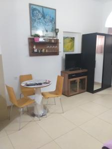 jadalnia ze stołem i krzesłami oraz telewizorem w obiekcie Guest House Orlihome w mieście Hajfa