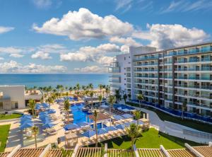 an aerial view of a resort with a pool and the ocean at Royalton Splash Riviera Cancun, An Autograph Collection All-Inclusive Resort in Cancún +278 photos