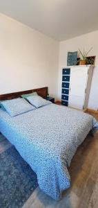 1 dormitorio con 1 cama con edredón azul en Gīte du café Truchet en Saint-Pancrace