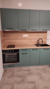 a kitchen with a sink and a stove and cabinets at Apartments Jerkin in Tribunj