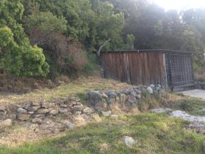 a fence and a stone wall in a field at Melipal Schuss ARG41 in San Carlos de Bariloche