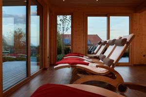 a room with a row of chairs in front of windows at Landhotel Haringerhof mit Saunawelt und Naturbadeteich in Grafenhausen