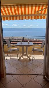una mesa y sillas en un balcón con vistas al océano en Studio cosy avec vue mer, en Ajaccio