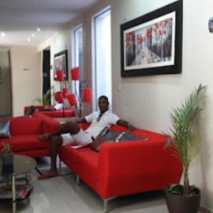 a man sitting on a red couch in a living room at Hotel Kallma Adventures in Ica