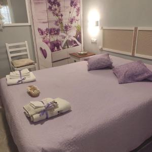 een slaapkamer met een bed met handdoeken en een stoel bij B&B Babay in Guspini