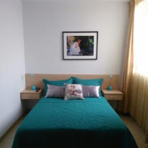 a bedroom with a bed with a green blanket at Hotel Kallma Adventures in Ica