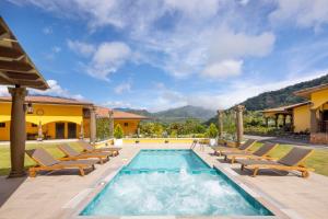 uma villa com uma piscina e espreguiçadeiras em Los Establos Boutique Resort - All Inclusive em Boquete