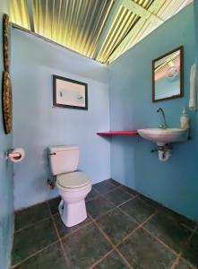 a bathroom with a toilet and a sink at Lower Dover Jungle Lodge & Maya Ruins in Unitedville
