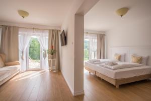 1 dormitorio con cama y ventana grande en Dwór i Dworek Leszczowate Wellness & Spa, en Ustrzyki Dolne