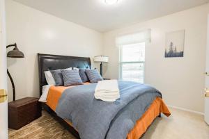 a bedroom with a bed with an orange and blue blanket at Spacious Stay near Airport, Downtown & Ski Resorts in North Salt Lake