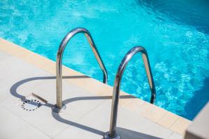una piscina con barandillas metálicas en una piscina en JT Curacao Apartments, en Jan Thiel