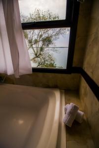 baño con bañera y ventana en Lofts y cabañas del Puerto en Ituzaingó