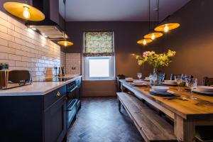 a large kitchen with a long wooden table and a window at Russell Court by Orenda-Luxe in Llandudno +104 photos