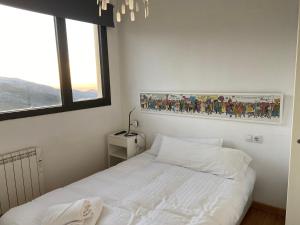 um quarto com uma cama e uma fotografia na parede em Ático dúplex en Monte Gorbea em Serra Nevada