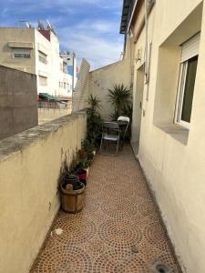 a small alley with a table and chairs in a building at Joli logement in Casablanca