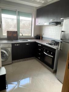 a kitchen with a sink and a stove top oven at Joli logement in Casablanca