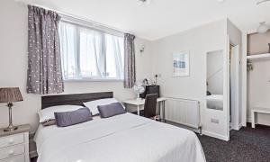 a bedroom with a large white bed and a desk at Alderberry Lodge in Newquay