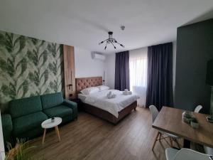 a bedroom with a bed and a couch and a table at M Lux Apartments in Banja Luka