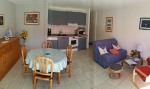 eine Küche und ein Wohnzimmer mit einem Tisch und einem Sofa in der Unterkunft Appartement "La Mouette" 3 etoiles in Saint-Philibert