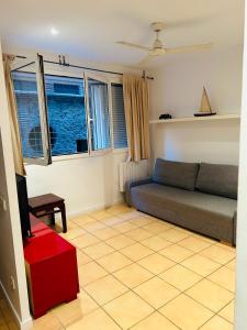 a living room with a couch and two windows at Céntrico apartamento a 150 metros de la playa. Parking* in Lloret de Mar