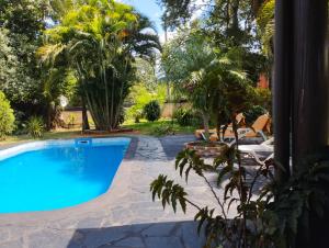 una piscina en un patio con palmeras en Los Tangueros en Puerto Iguazú