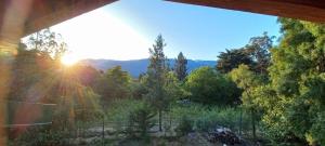 vistas a la puesta de sol sobre un bosque en Cafuné Cabañita Norte en El Bolsón